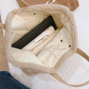 Detail of beige fleece tote bag interior showing large capacity and magnetic metal closure