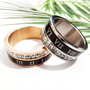 Macro detail of stainless steel rings with Roman numerals and inlaid square crystals