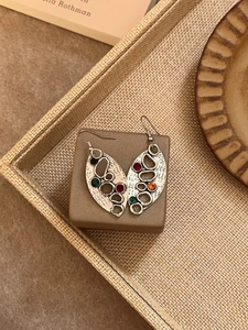 Vue détaillée de boucles d'oreilles feuilles en argent vintage avec strass colorés