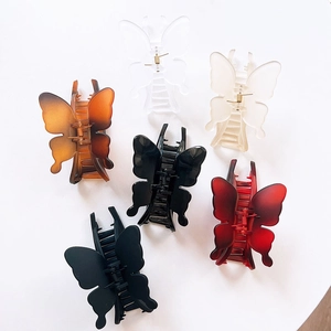 Large butterfly hair claw clips in various colors including amber and matte black