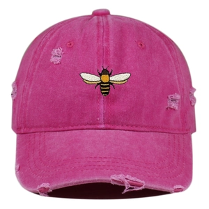 Close-up of bee embroidery on pink distressed washed baseball cap with torn details