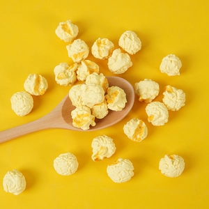 Macro detail of realistic round popcorn props on a wooden spoon with yellow background
