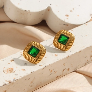 Detailed macro view of vintage 18K gold-plated earrings with green square zircon