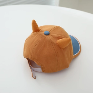 Cartoon dinosaur kids baseball cap in mustard yellow with blue brim and 3D horns