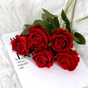 Artificial velvet red roses bouquet on white fur background for wedding decor