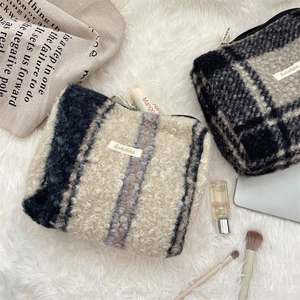 Detailweergave van zachte sherpa make-uptassen met elegante streep- en ruitpatronen voor dames