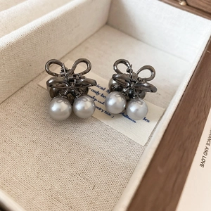Close-up of elegant mini butterfly hair claws with pearls and dark metallic finish