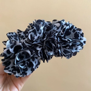 Close-up of leopard print fabric flower hair clip with three-dimensional petals