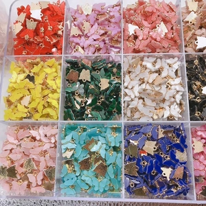 Macro shot of colorful acrylic butterfly charms with gold metal frames in storage box