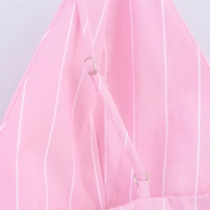 Détail macro de la bretelle réglable sur robe à rayures roses avec boucle en métal argenté
