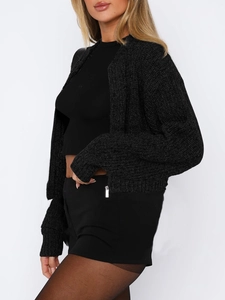 Detail view of a black cropped knit cardigan featuring long sleeves and ribbed texture