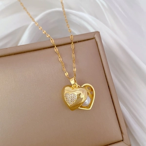 Macro view of gold heart pendant with sparkling crystals and white pearl on silk background