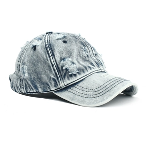 Detail of light blue distressed denim baseball cap with vintage frayed hole design