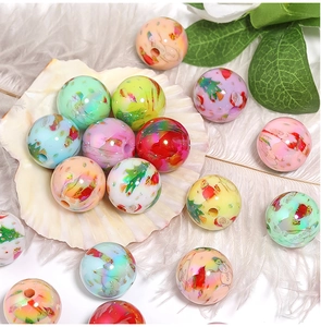 Close-up of colorful acrylic beads with Santa Claus and snowflake prints on shell