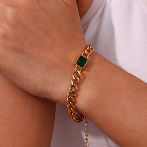Detail of 18K gold plated Cuban chain bracelet with rectangular green zircon gemstone