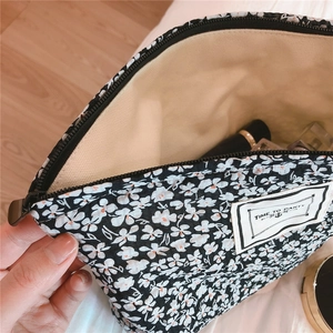 Detail view of floral makeup bag with 'TIME TO PARTY' label and spacious interior