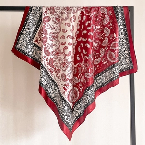 Classic two-tone paisley silk square scarf displayed elegantly on a metal stand
