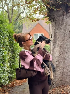 Close-up of pink and brown striped polo knitwear with a luxury suede handbag in autumn