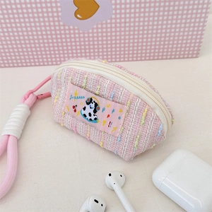 Vue détaillée de la pochette à écouteurs en tweed rose avec patch dalmatien mignon