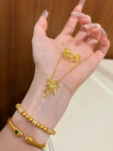 Detail eines Gold-Schmucksets mit funkelnden Feuerwerk-Anhängern auf der Hand