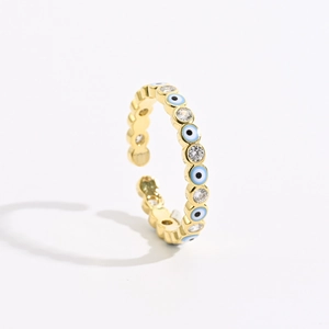 Detailed macro of gold adjustable evil eye ring with blue enamel and clear zircons