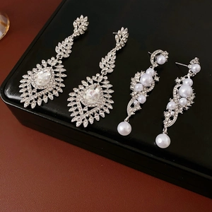 Detailed view of silver-tone crystal earrings with pear-shaped stones and white pearls