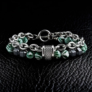 Detail of men's double-layer malachite bead bracelet with silver chain on black leather