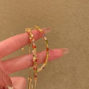 Bracciale regolabile in oro con strass quadrati colorati tenuto a mano dettaglio