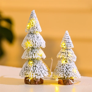 Close-up of dual flocked cedar Christmas trees with LED lights and natural wooden bases