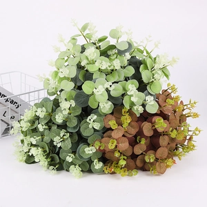 Gros plan de feuilles d'eucalyptus artificielles vertes et brun-rouge avec petits bourgeons