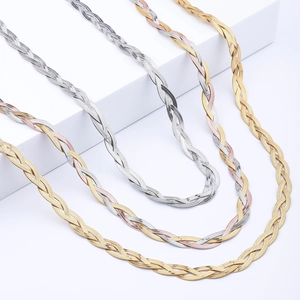 Detailed view of three-tone braided flat snake chain necklaces on geometric display