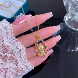 Titanium Hamsa necklace with colorful zircons and Saint Jude pendant held by model