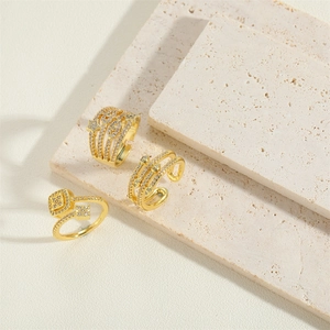 Three elegant 14K gold plated star zircon rings on a minimalist beige stone background