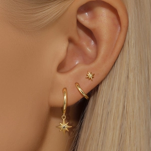 Close-up of gold s925 silver earring set with star pendant and pearl opal details