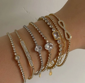 Detail of layered gold and silver zircon tennis bracelets on a female wrist