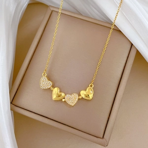 Detail of gold titanium steel heart pendants with crystals on a fine chain jewelry box