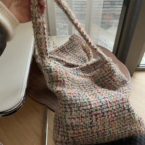 Macro detail of the colorful textured tweed fabric on a stylish woven shoulder tote bag