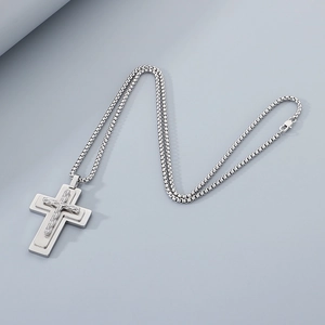 Close-up of double-layered silver cross pendant on a stainless steel pearl box chain