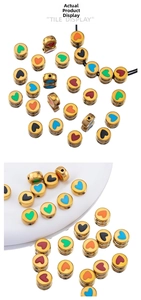 Detail of round golden beads with colorful enamel hearts for DIY jewelry making