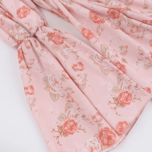 Gros plan sur le tissu en mousseline à imprimé rose avec manches à volants délicats