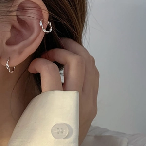 Minimalist silver Mobius loop hoop earrings and ear cuff set worn on a model ear