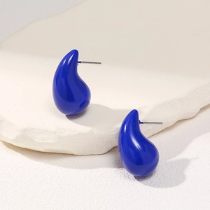 Macro detail of royal blue teardrop earrings with smooth glaze finish on white stone