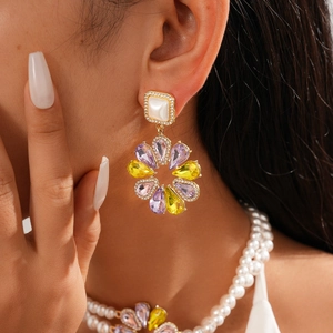 Close-up of vintage baroque flower earrings with colorful rhinestones on a model