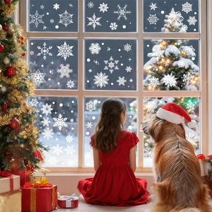 Detail of white snowflake window clings on glass with a cozy Christmas scene background