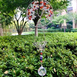 Macro shot of life tree suncatcher with crystal ball and silver butterfly hanging outdoor