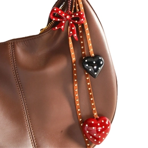 Handmade brown leather bag charm with red and black polka dot hearts and bow detail