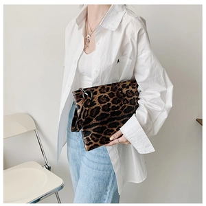 Detail of leopard print clutch with wrist strap and soft faux fur texture for women
