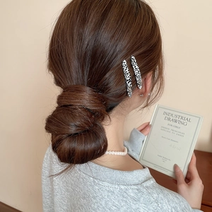 Dettaglio di fermagli per capelli maculati sui capelli scuri raccolti della modella