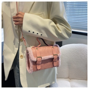 Detail of pink faux suede handbag featuring soft plush trim and golden metallic hardware buckle