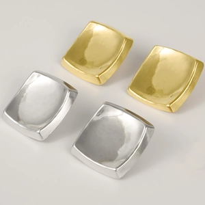 Detailed view of square stud earrings in polished gold and silver stainless steel finish